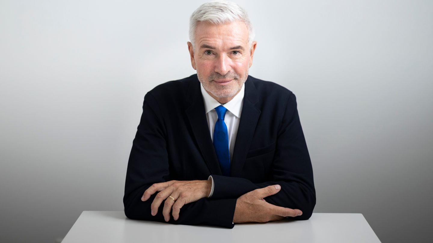 Roger Kusch lehnt mit verschränktem Armen an einem Schreibtisch und lächelt leicht Roger Kusch lehnt mit verschränktem Armen an einem Schreibtisch und lächelt leicht