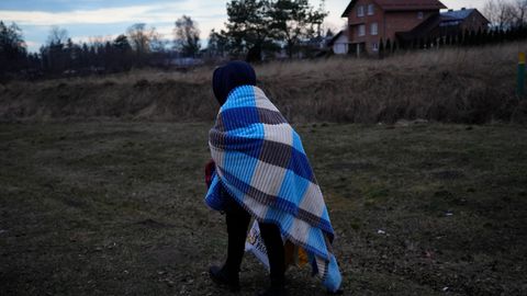 Ein Flüchtling, der vor dem Konflikt in der benachbarten Ukraine geflohen ist, geht über eine Wiese
