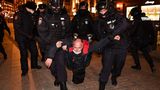 Polizisten führen gewaltsam einen Demonstranten ab