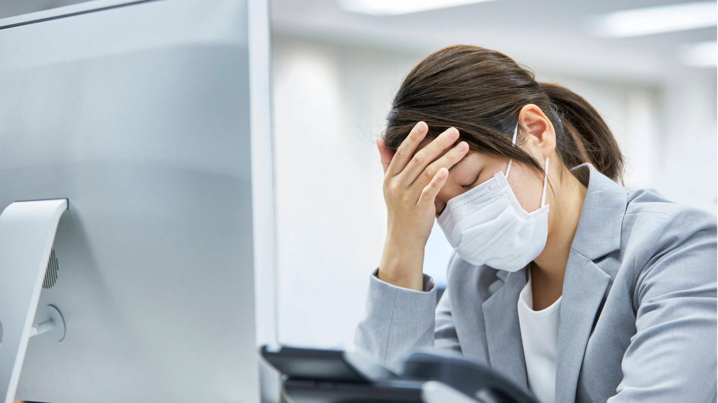 Verzweifelte Frau sitzt vor einem Computer