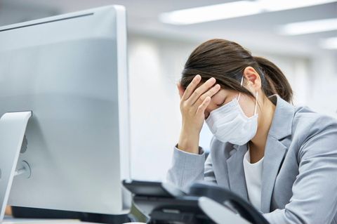 Verzweifelte Frau sitzt vor einem Computer