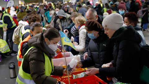 Helfer verteilen Lebensmittel an Menschen, die vor dem Krieg in der Ukraine fliehen, am Hauptbahnhof in Berlin