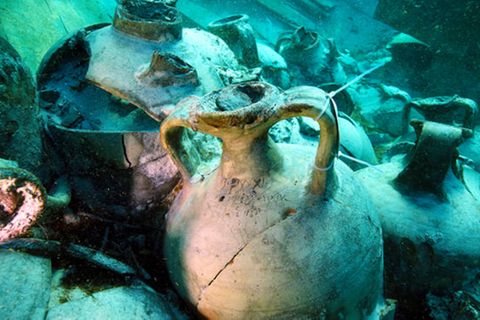 Im grünlich schimmernden Wasser sind Amphoren und andere Gefäße zu sehen