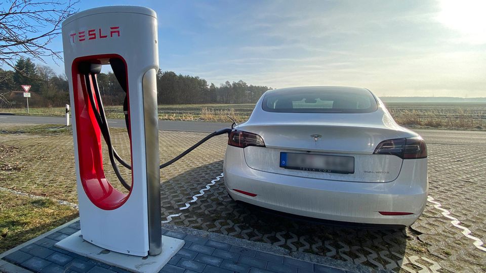 Ein Tesla Model 3 steht an einem Supercharger