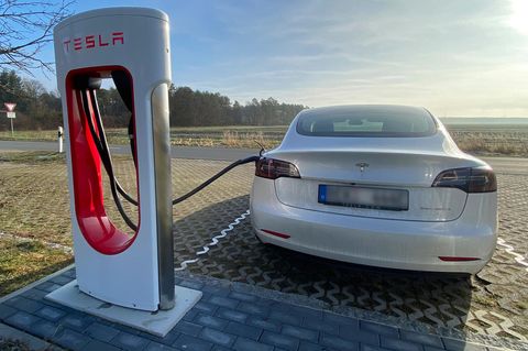 Ein Tesla Model 3 steht an einem Supercharger