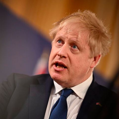Der britische Premier Boris Johnson vor einem Hintergrund in Ukraine-Farben