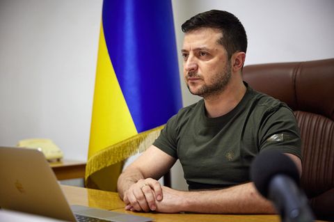 Der Präsident der Ukraine Wolodymyr Selenskyj sitzt an einem Tisch