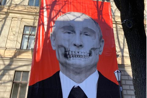 Ein großes Plakat mit Putin als Totenkopf hängt an einer Hausfassade