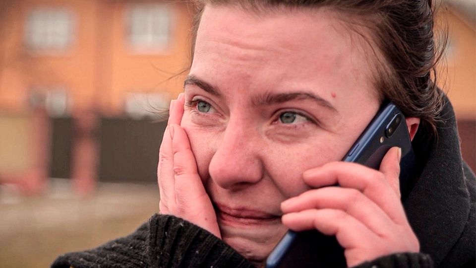 Ukraine: Humanitäre Korridore Eine weinende Frau telefoniert mit ihrem Smartphone.