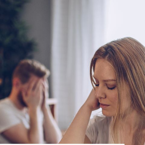 Eine Frau und ein Mann, die eine Beziehung haben, sitzen nebeneinander im Bett