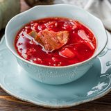 Borschtsch aus dem Schnellkochtopf  Zutaten:   400 g geräucherte Schweinerippchen, 250 g Weißkohl, 3 Kartoffeln, 1 Karotte, 1 Rote Bete, 1 Zwiebel, Zucker, ½ rote Paprika, 200 g geschälte Tomaten aus der Dose, 2 EL Tomatenmark, 3 schwarze Pfefferkörner, 2 Nelken, Piment, 2 Lorbeerblätter, 3 Knoblauchzehen, 4 EL Pflanzenöl (am besten Sonnenblumenöl), Salz  Zubereitung:  1. Kartoffeln schälen und würfeln.  2. Die Zwiebel schälen und fein würfeln. Karotte, Rote Bete und Paprika in Julienne-Streifen schneiden.  3. Gießen Sie etwa 4 EL Öl in den Schnellkochtopf und fügen Sie Paprika, Zwiebel, Karotte und Rote Bete hinzu. Salzen Sie alles und braten Sie das Ganze für 15 Minuten.  4. Dann die geräucherten Rippchen dazugeben. Zerkleinern Sie diese, wenn Sie mögen.  5. Schließlich die geschälten Tomaten hinzufügen. Nach Geschmack salzen und etwa ½ TL Zucker hinzufügen, um den Geschmack auszugleichen.  6. Den Kohl klein schneiden und zusammen mit den Kartoffeln in den Topf geben.  7. Fügen Sie etwa 2 Liter Wasser hinzu und kochen Sie das ganze für 40 Minuten. Wenn das Gemüse gar ist, die Knoblauchzehe fein hacken und in den Topf geben. Mit sauerer Sahne servieren.