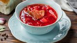 Borschtsch aus dem Schnellkochtopf  Zutaten:   400 g geräucherte Schweinerippchen, 250 g Weißkohl, 3 Kartoffeln, 1 Karotte, 1 Rote Bete, 1 Zwiebel, Zucker, ½ rote Paprika, 200 g geschälte Tomaten aus der Dose, 2 EL Tomatenmark, 3 schwarze Pfefferkörner, 2 Nelken, Piment, 2 Lorbeerblätter, 3 Knoblauchzehen, 4 EL Pflanzenöl (am besten Sonnenblumenöl), Salz  Zubereitung:  1. Kartoffeln schälen und würfeln.  2. Die Zwiebel schälen und fein würfeln. Karotte, Rote Bete und Paprika in Julienne-Streifen schneiden.  3. Gießen Sie etwa 4 EL Öl in den Schnellkochtopf und fügen Sie Paprika, Zwiebel, Karotte und Rote Bete hinzu. Salzen Sie alles und braten Sie das Ganze für 15 Minuten.  4. Dann die geräucherten Rippchen dazugeben. Zerkleinern Sie diese, wenn Sie mögen.  5. Schließlich die geschälten Tomaten hinzufügen. Nach Geschmack salzen und etwa ½ TL Zucker hinzufügen, um den Geschmack auszugleichen.  6. Den Kohl klein schneiden und zusammen mit den Kartoffeln in den Topf geben.  7. Fügen Sie etwa 2 Liter Wasser hinzu und kochen Sie das ganze für 40 Minuten. Wenn das Gemüse gar ist, die Knoblauchzehe fein hacken und in den Topf geben. Mit sauerer Sahne servieren.