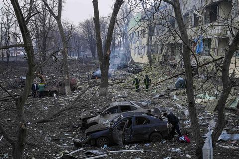 Ukrainische Rettungskräfte gehen an einer durch einen Angriff beschädigten Geburtsklinik in Mariupol vorbei