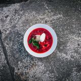 Borschtsch Guerilla Style mit Miso  Zutaten:  2 l Wasser, 2 Rote Bete, 1 Zwiebel, 3-4 Kartoffeln, ½ Paprika,  ½ Karotte, 200 g Sauerkraut (mit Salzlake), 2-3 Lorbeerblätter,  2 Esslöffel Tomatenmark, 1 Esslöffel Honig, 1 gehäufter  Esslöffel dunkle Misopaste, Salz, schwarzer Pfeffer, Petersilie, Crème fraîche  Zubereitung:  1. Die Rote Bete schälen, halbieren, mit Wasser bedecken und 40 Minuten lang kochen, bis sie weich sind. Die Zwiebel in den Sud geben und weiter kochen.  2. Die Kartoffeln in kleine Würfel schneiden und zum dem Sud geben. Die Hälfte der Möhren in Streifen schneiden. Kartoffel schälen, in 1 cm Würfeln schneiden. Möhren und Kartoffeln in den Topf geben. Alles weiter kochen lassen.  3. Die Paprika und die restlichen Zwiebel in Würfel schneiden. In einer Pfanne mit etwas Pflanzenöl anbraten ca 5 min anbraten.  4. Das Tomatenmark hinzufügen und weitere 2-3 Minuten köcheln lassen.  5. Nun die Rote Bete aus dem Sud nehmen, etwas abkühlen lassen und in 1 cm Würfeln schneiden. Die kleingeschnittenen Rote Bete und die Zwiebel Paprikamischung in den Sud geben.  6. Die Misopaste in etwas sud auflösen und zu dem Sud geben. Wenn das ganze Gemüse fertig ist, das Sauerkraut mit der Salzlake und mit den Lorbeerblättern zum Borschtsch geben. 3 Minuten kochen lassen und abschmecken.  7. Mit Salz, Pfeffer und Honig abschmecken Borschtsch 20 Minuten ziehen lassen. So wird er durchzogen und mit Aromen gesättigt. Mit 1 Löffel Crème fraîche und Petersilie garnieren. Sofort heiß servieren. 