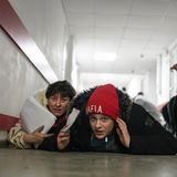 Menschen suchen während des Beschusses Schutz am Boden eines Krankenhauses