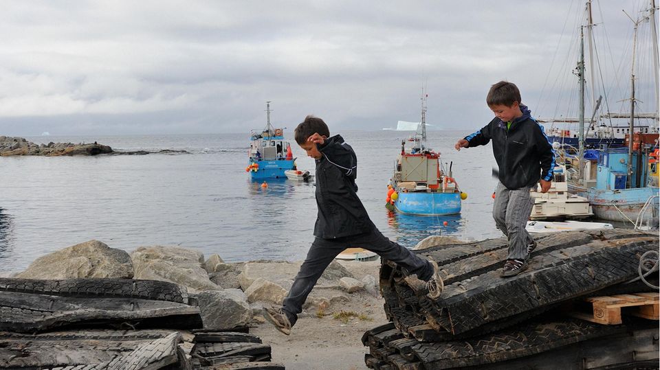 Zwei Inuit-Kinder spielen am Hafen