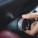 Klimaanlage aus!    Die Klimaanlage verbraucht Leistung und Benzin. Die modernen Systeme von Neuwagen deutlich weniger als die Anlagen in älteren Modellen – aber am Mehrverbrauch ist nicht zu rütteln.  Am stärksten schlägt das zu Buche, wenn ein in der Sonne aufgeheiztes Fahrzeug nur für kurze Strecken bewegt wird. Aber sollte man auf den Dienst der Anlage verzichten? Zunächst sollte sich der Besitzer vor Augen halten, dass er sie ja für gutes Geld gekauft hat. Eine Entscheidung, die ökonomisch unsinnig wird, wenn man deren Mehrgewicht durch die Straßen kutschiert, aber sich weigert, sie zu nutzen.  Der Mehrverbrauch lässt sich so illustrieren: Steht ein Wagen im Stau in der prallen Sonne, beträgt der Mehrverbrauch pro Stunde etwa 0,34 Liter. Dafür sitzt man verhältnismäßig kühl. Will man diesen Wert einsparen, befindet man sich schnell in einem über sechzig Grad heißen Gehäuse. Die Ersparnis ist also mit einem erheblichen Unwohlsein verbunden, bei Kindern und älteren Personen können sogar ernsthafte gesundheitliche Beeinträchtigungen auftreten.  Fährt der Wagen, wird die abgeschaltete Klimaanlage meist durch geöffnete Fenster kompensiert. Außerhalb geschlossener Ortschaften führen die Luftverwirbelungen dann zu einem Mehrverbrauch, der die Ersparnis schnell halbiert.  Fazit: Ein Tipp nur für spartanische Naturen; das begrenzte Einsparvolumen wird mit einem deutlichen Mangel an Komfort erkauft