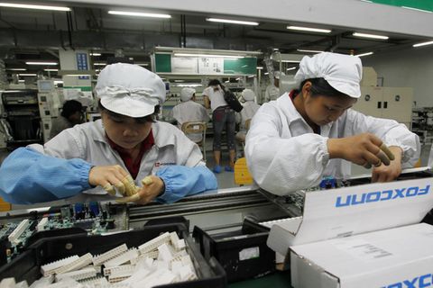 Foxconn-Mitarbeitende am Band bauen Technik zusammen