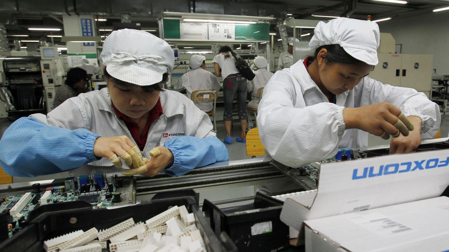 Foxconn-Mitarbeitende am Band bauen Technik zusammen