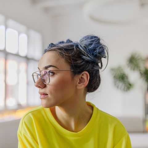 Frau mit Brille und gelbem Pulli schaut zur Seite