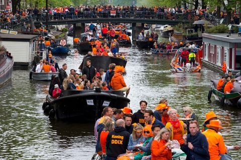 Boote mit vielen Menschen fahren durch eine Gracht