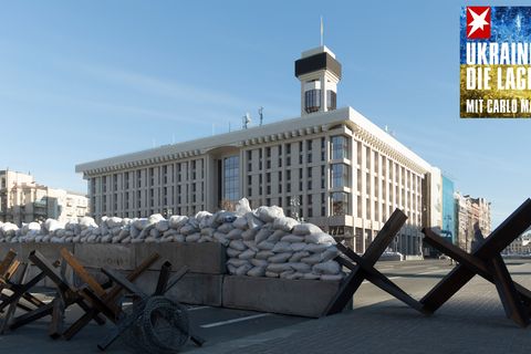 Panzersperren und Sandstäcke liegen quer über eine Straße auf dem Maidan in Kiew, Ukraine