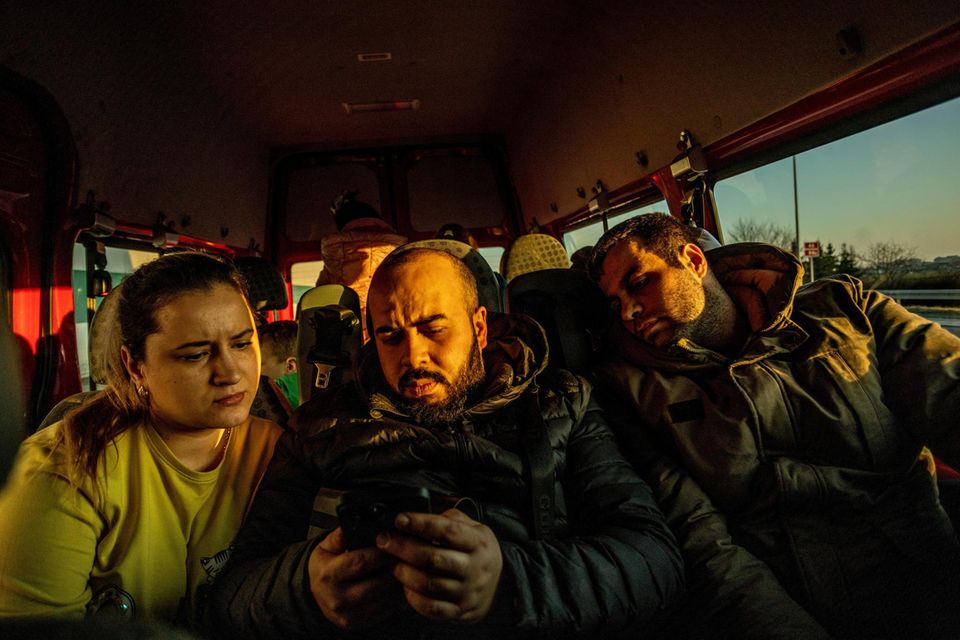 VOE STERN 12/2022 TITELGESCHICHTE PUTINS RUSSLAND - PUTINS REICH - LOS GEHT'S, JALLA - KRIEG IN DER UKRAINE - Ukraine Krieg (FINAL) >> Syrische Freiwillige aus Sinzig und Remagen bringen Hilfsgueter fuer die Ukraine und nehmen Gefluechtete Syrer u... Zwei Männer und eine Frau schauen auf ein Handy