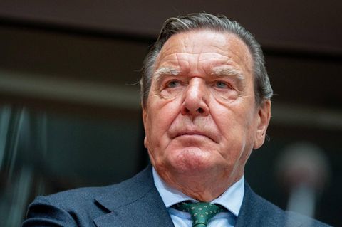 Ein älterer weißer Mann im Anzug schaut ernst über den Betrachter hinweg