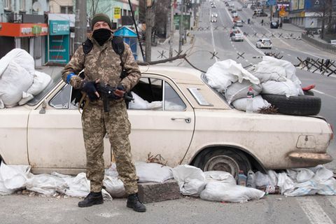In Kiew haben die Soldaten überall Straßensperren errichtet, so wie hier mit einem Auto, Sandsäcken und Müll. Im Hintergrund sind weitere Sperren zu erkennen, die russische Panzer aufhalten sollen