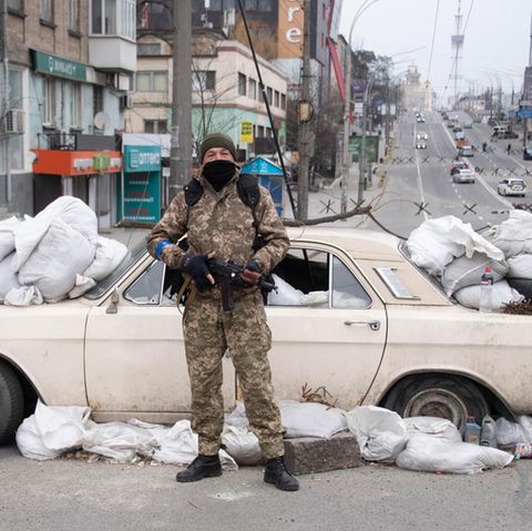 In Kiew haben die Soldaten überall Straßensperren errichtet, so wie hier mit einem Auto, Sandsäcken und Müll. Im Hintergrund sind weitere Sperren zu erkennen, die russische Panzer aufhalten sollen