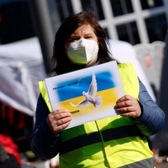 Eine ehrenamtliche Helferin empfängt Geflüchtete aus der Ukraine in Köln