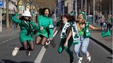 Grün gekleidete Frauen springen in die Luft