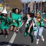 Grün gekleidete Frauen springen in die Luft