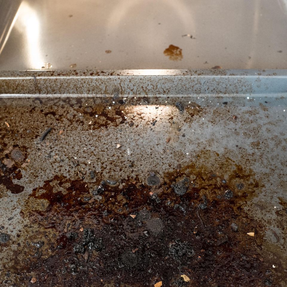 Ein dreckiges Backblech, das in den Ofen geschoben wird