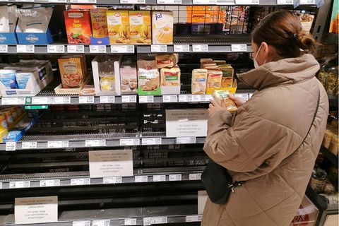Frau steht vor einem Supermarkt-Regal