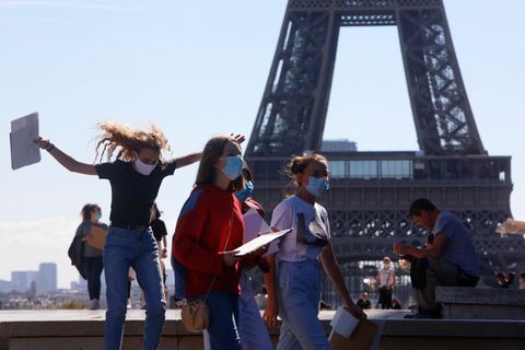 Passanten laufen vor dem Eiffelturm in Paris.