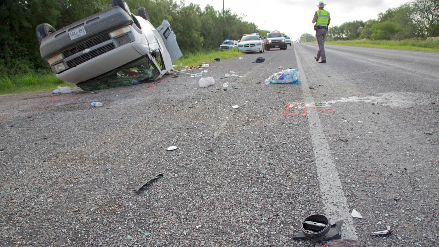 Auto liegt auf dem Dach am Straßenrand