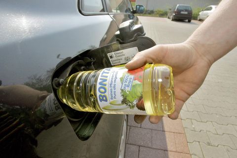 Speiseölflasche in Tank eines Autos gesteckt