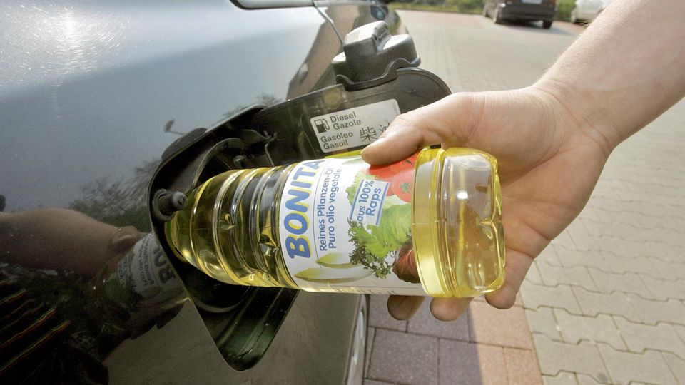 Speiseölflasche in Tank eines Autos gesteckt