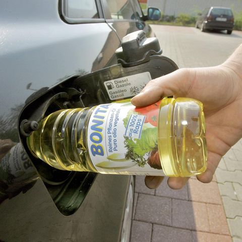 Speiseölflasche in Tank eines Autos gesteckt