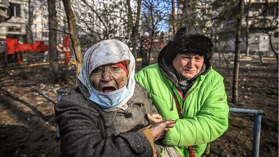 Eine alte verdreckte Frau wird von einer Caritas-Mitarbeiterin gestützt und geführt