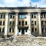 An einem Gebäude mit hohen Säulen sind Brandspuren zu sehen