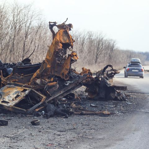 Ein zerstörtes Auto auf der Straße hinaus aus Mariupol