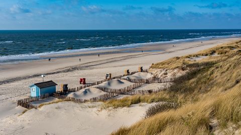 In der Vorsaison in den Dünen auf Sylt: Vereinzelte Strandbesucher laufen am Strand der Nordsee entlang.