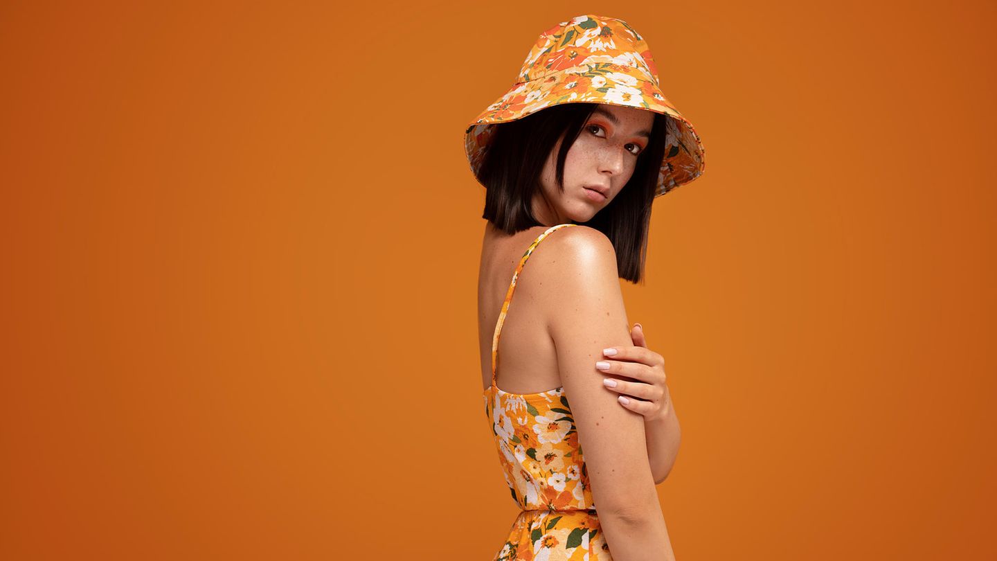 Frau trägt den Bucket-Hat-Trend mit Blumenprint