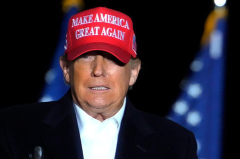Donald Trump mit roter MAGA-Mütze vor US-Flagge