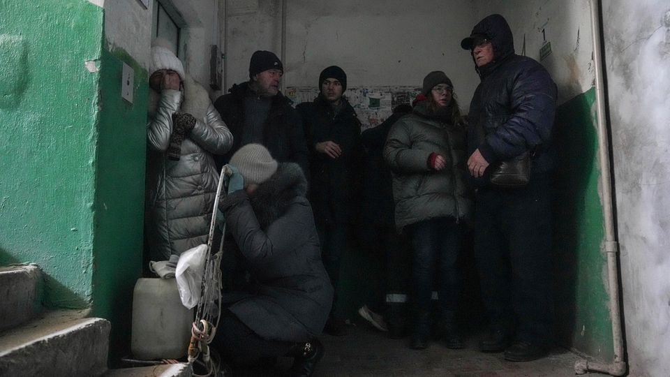 Menschen schützen sich vor Beschuss in einem Eingang zu einem Wohnhaus in Mariupol Menschen schützen sich vor Beschuss in einem Eingang zu einem Wohnhaus in Mariupol