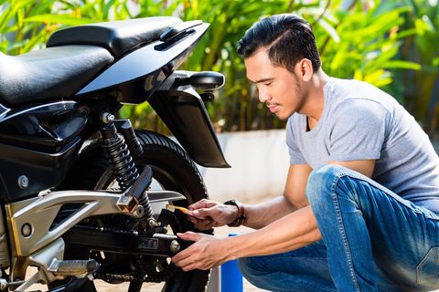 Ein junger Mann wartet ein Motorrad