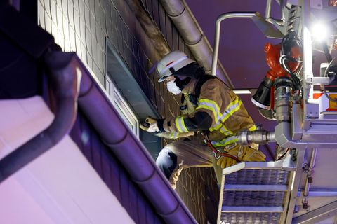 Feuerwehrmann blickt durch ein Fenster