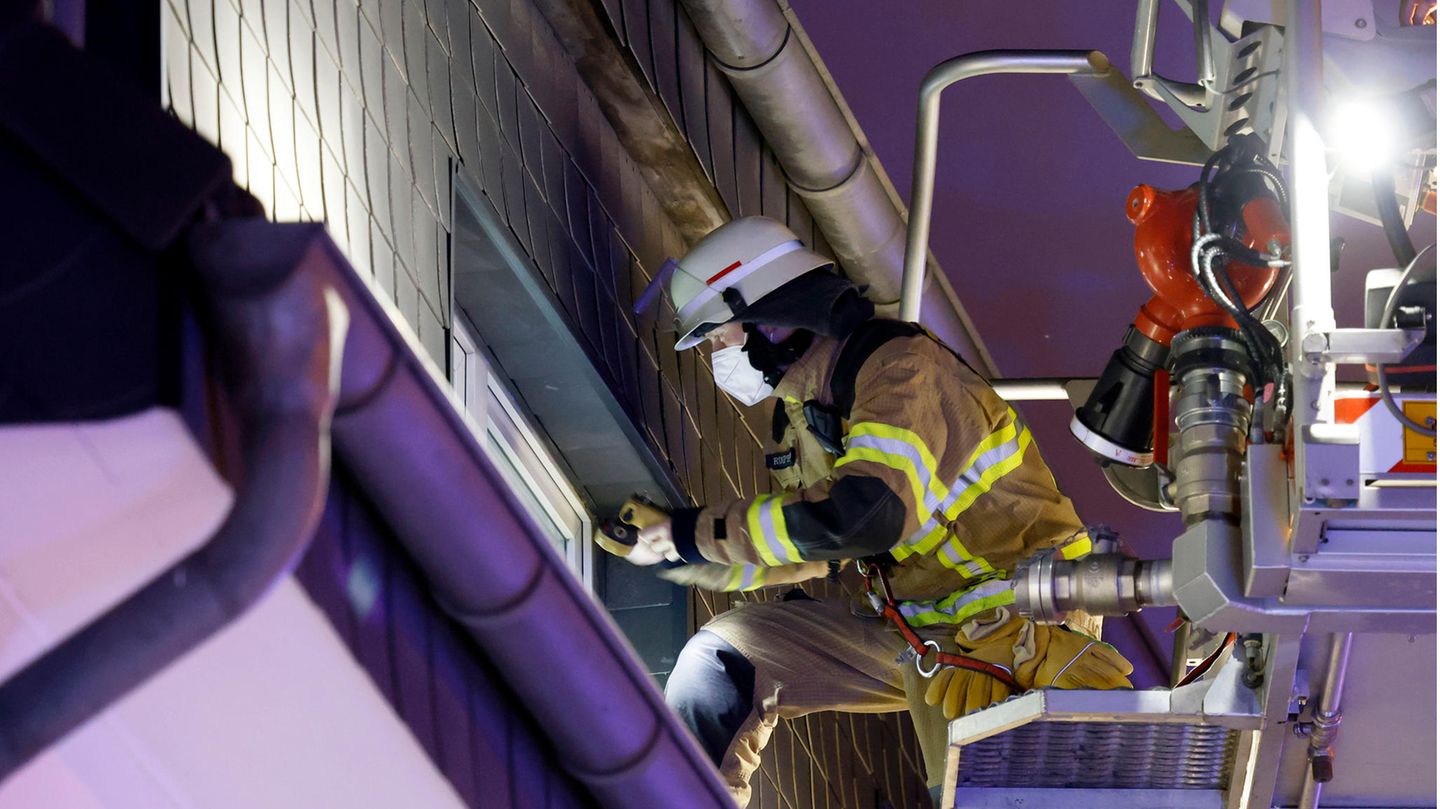 Feuerwehrmann blickt durch ein Fenster